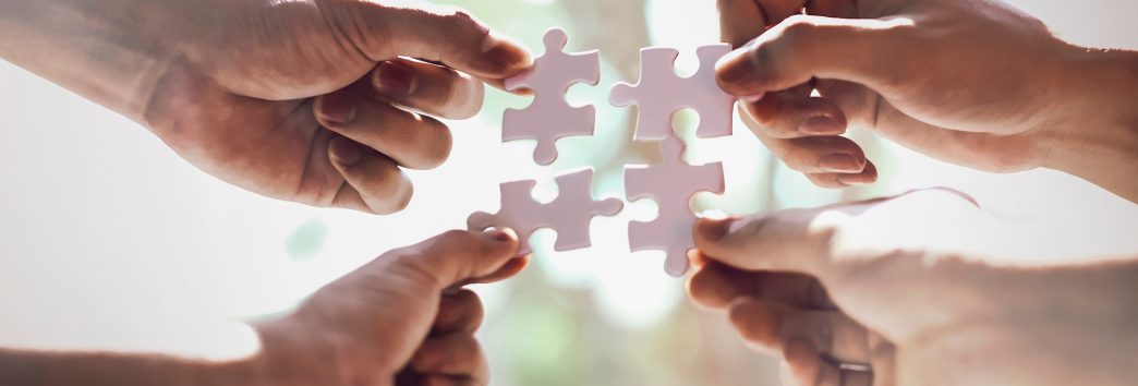 Closeup hand of business people connecting jigsaw puzzle with sunlight effect, Business solutions and represent team support and help concept, success and strategy concept