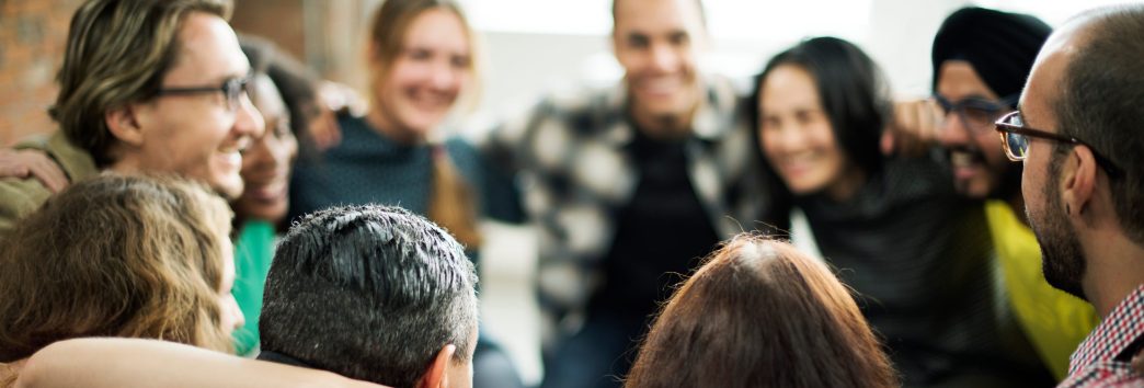 Happy people huddling in a room