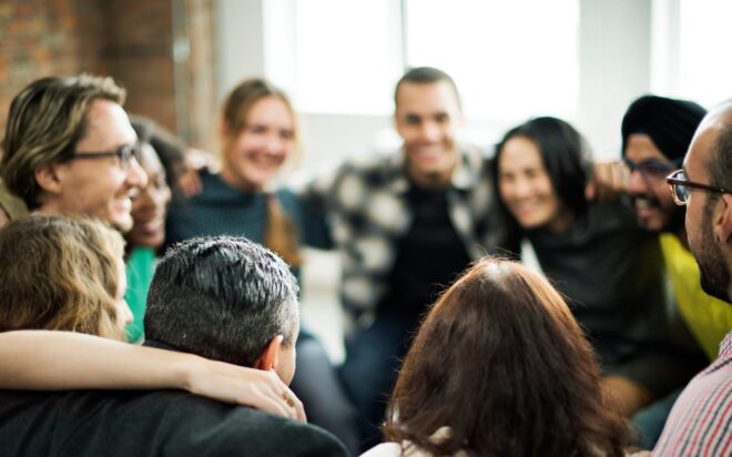 Happy people huddling in a room